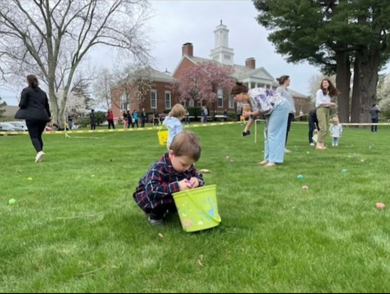 Photo of kids running around on the town common collecting eggs